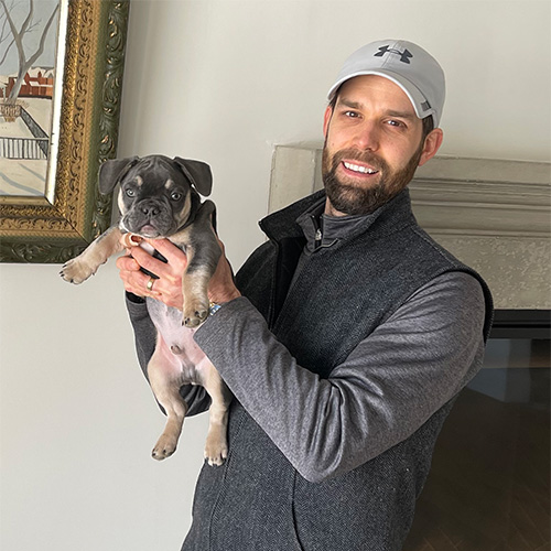 Gus the dog being held by fireplace